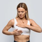 middle aged blonde woman examining her breasts
