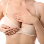 Young woman checking her breasts